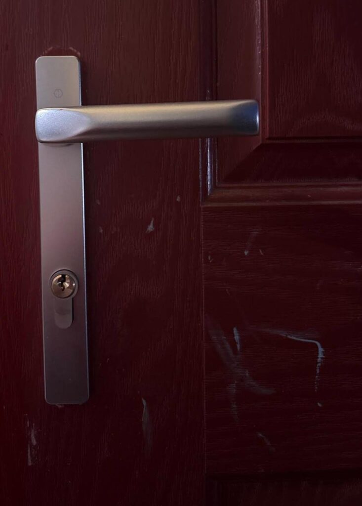 Front door with a new satin-silver lever handle and cylinder fitted after a lost-keys lockout in Morda